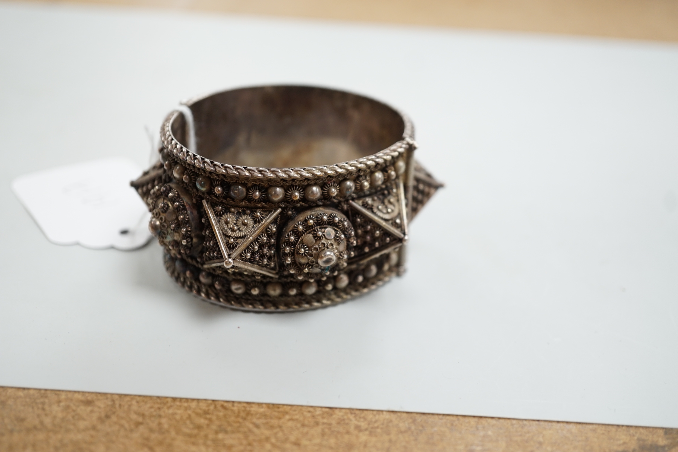 A Middle Eastern white metal hinged bangle.